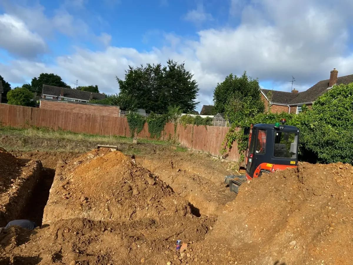Excavator digging foundations for extensive landscaping project