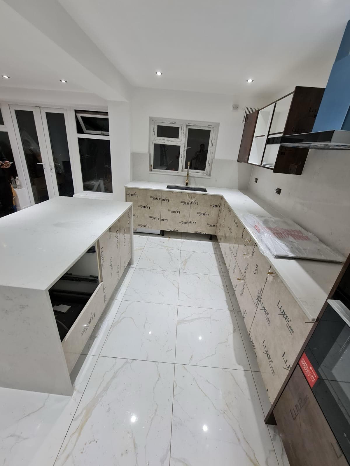 Completed kitchen with island and marble flooring